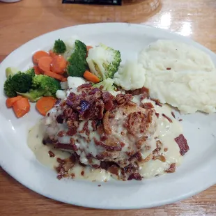Checked cordon bleu with a side of fresh vegetables and mashed potatoes.