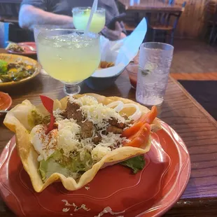 This is a picture of a very delicious taco salad with a margaritas. Mine is on the rocks, while the other margarita is frozen.