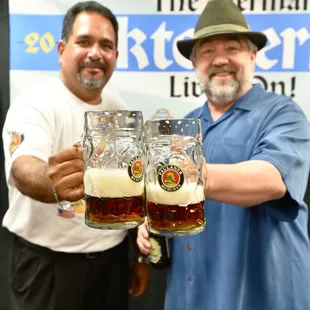 two men holding beer glasses