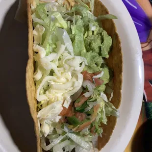 a taco with lettuce and tomatoes
