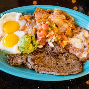 El Patio House Breakfast: Red Chilaquiles, Juicy Carne Asada, Two Eggs your way, guacamole, salsa fresca, and our famous beans. Best Seller.