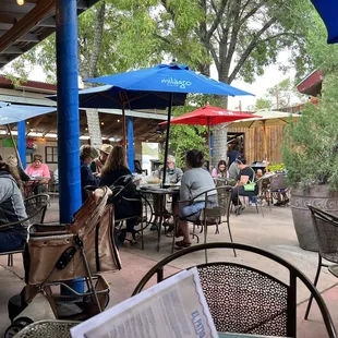 people sitting at tables with umbrellas