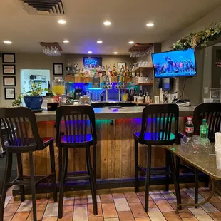 a bar with chairs and a television