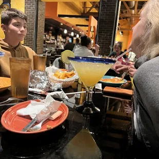 a man and a woman sharing a margarita
