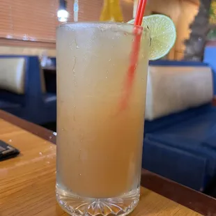 a drink with a straw and a lime slice