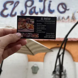 a hand holding a business card