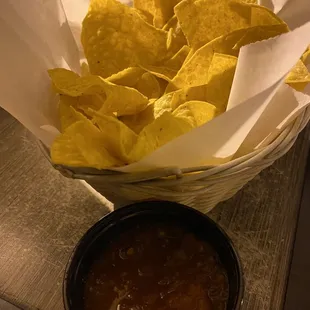 a basket of tortilla chips and a bowl of salsa