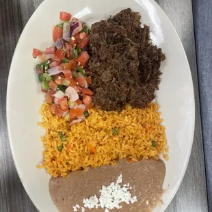 Barbacoa, smooshed beans, rice with vegetables and a pico de gallo