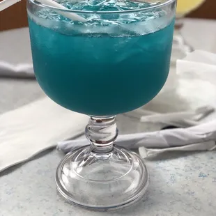 a blue drink in a glass