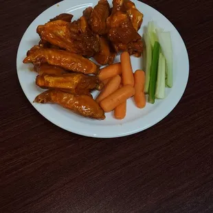 a plate of chicken wings and carrots