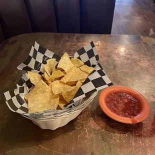 a basket of tortillas and a bowl of salsa