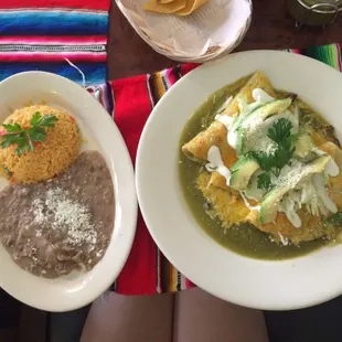 Beef enchiladas with green sauce and rice and beans on the side