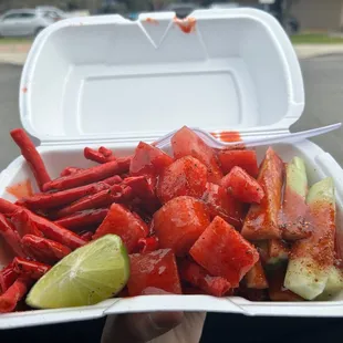a hand holding a container of food