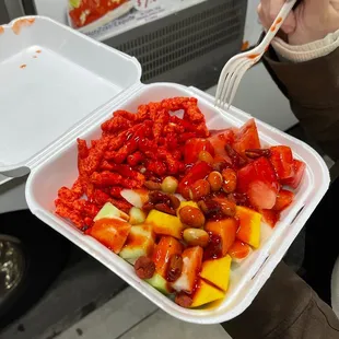 a person holding a container of food