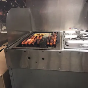 a bunch of hotdogs being cooked