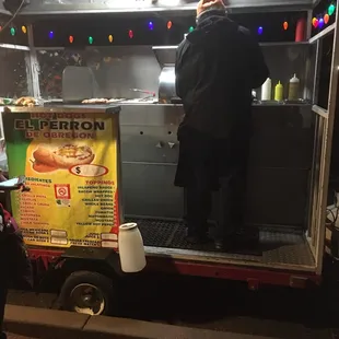 a man standing in the back of a food truck