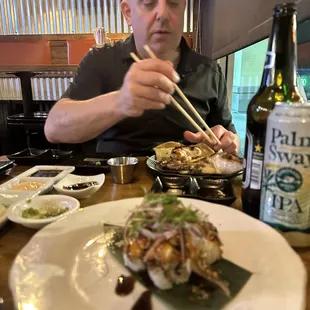 a man eating sushi with chopsticks