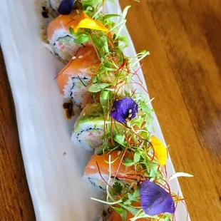 a long rectangular plate with sushi on it