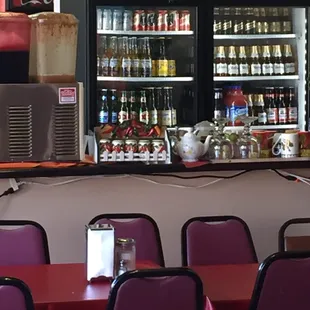 a table with chairs and a cooler in the background