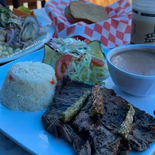 a plate of steak, rice, and salad