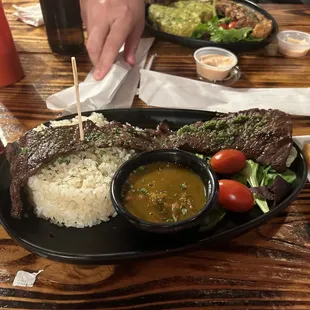 Churrasco with side of rice and beans and salad.