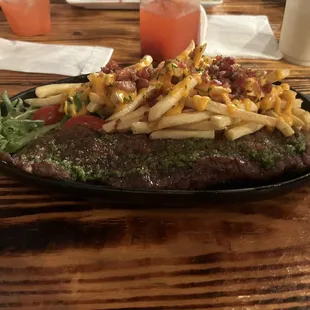 Churrasco with side of loaded fries and salad