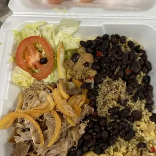 Arroz con pollo, habichuelas negras y ensalada.