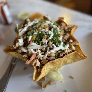 a taco dish on a plate with a fork