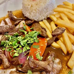 a plate of food with meat and french fries