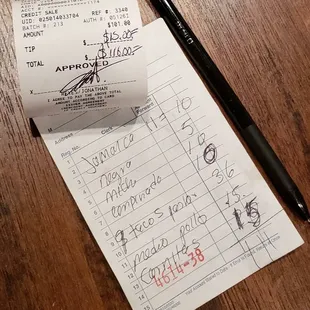 a receipt and a pen on a table