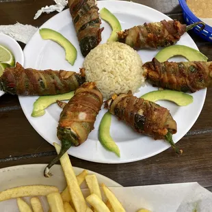 a plate of bacon wrapped avocados and rice