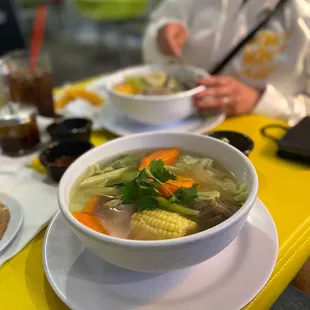 a bowl of soup on a yellow table