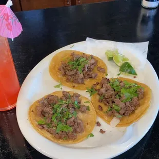a plate of tacos and a drink