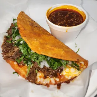 a sandwich with a side of sauce