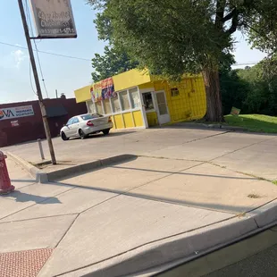 a car parked in front of a yellow building