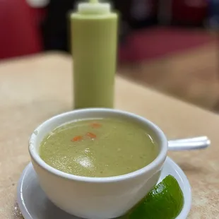 a bowl of soup and a lime