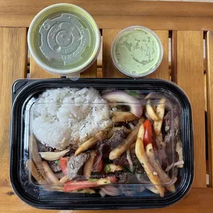 Lomo Saltado served with rice and french fries. Included Aguadito Soup and Aji Verde.