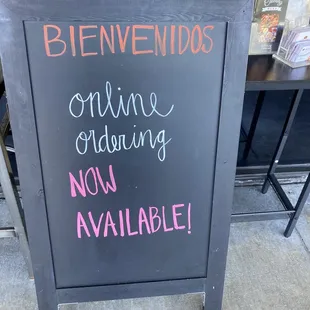 a blackboard with a sign that reads bienvenidos online ordering now available