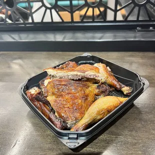a roasting chicken in a plastic container