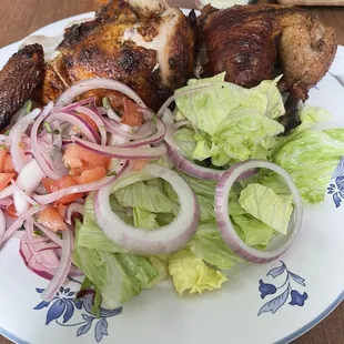 Half chicken with the side salad and tomato and onion salad