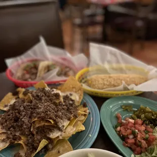 Nachos- Whole, Elote, Carnitas Tacos and Rice Bowl at the bottom