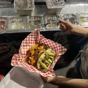 a hand holding a hotdog