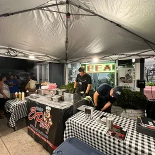 a man preparing food under a tent
