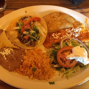 Combo. Beef taco, empanada, cheese enchilada with rice, refried beans, with your typical accoutrement on the side.