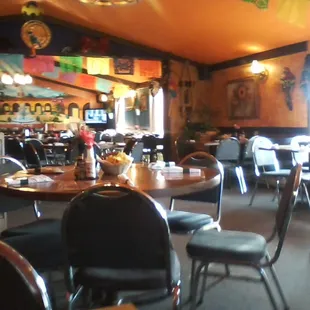 A view of the colorful interior of the restaurant with a glimpse of the mural on the far wall.