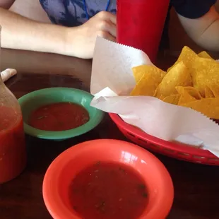 Complimentary chips and salsa with horchata in the background.
