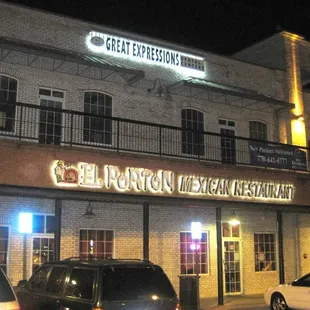 cars parked in front of a building at night