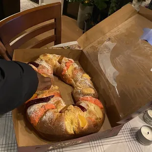 a person holding a box of bread