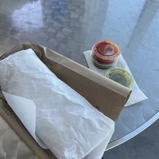 a table with a sandwich and condiments