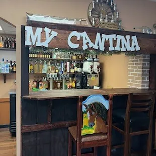 a bar with chairs and a bottle